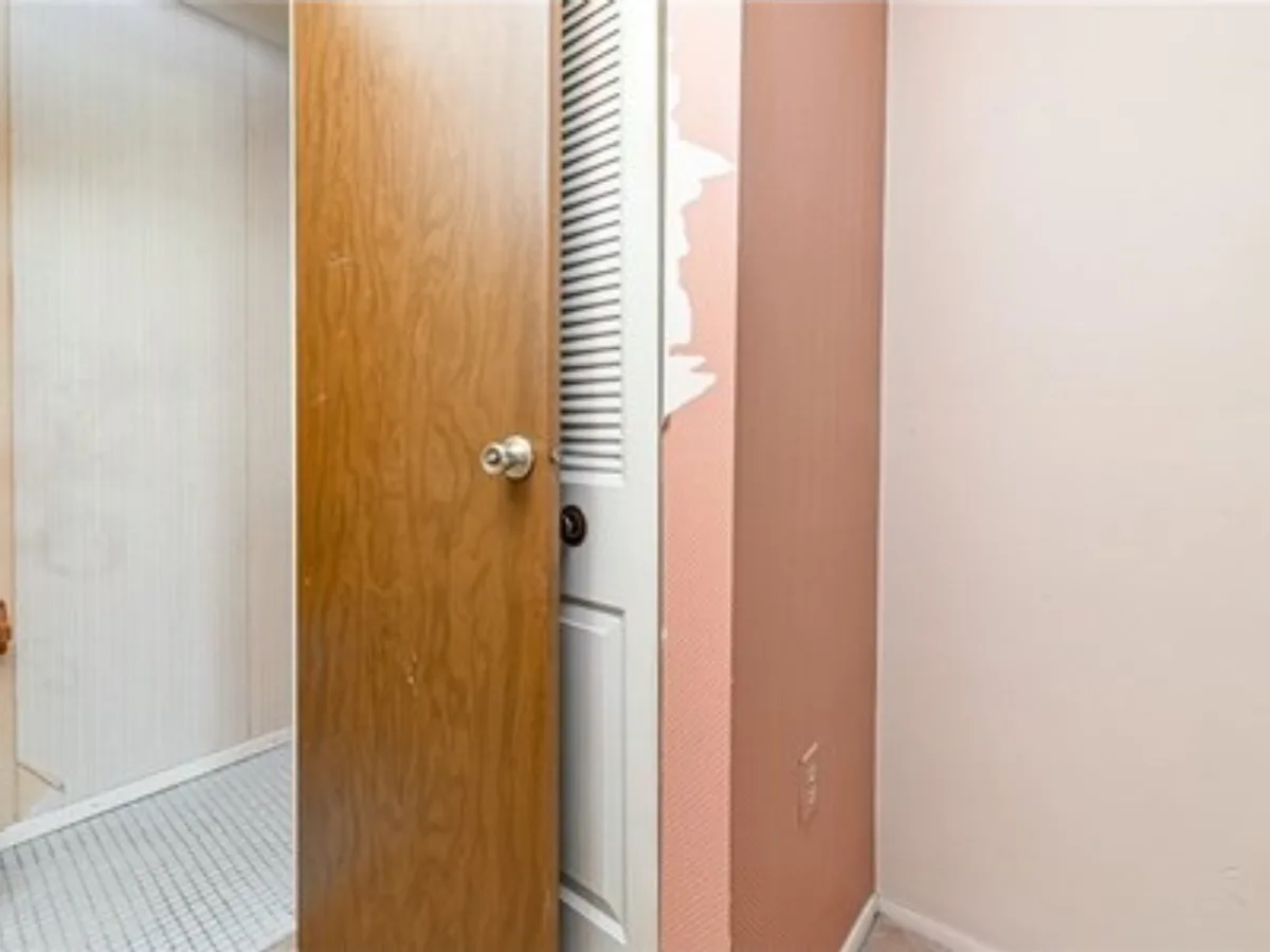 Before: narrow powder room going from a dated pink space to a clean half bath with a white vanity and dark wood-look floor