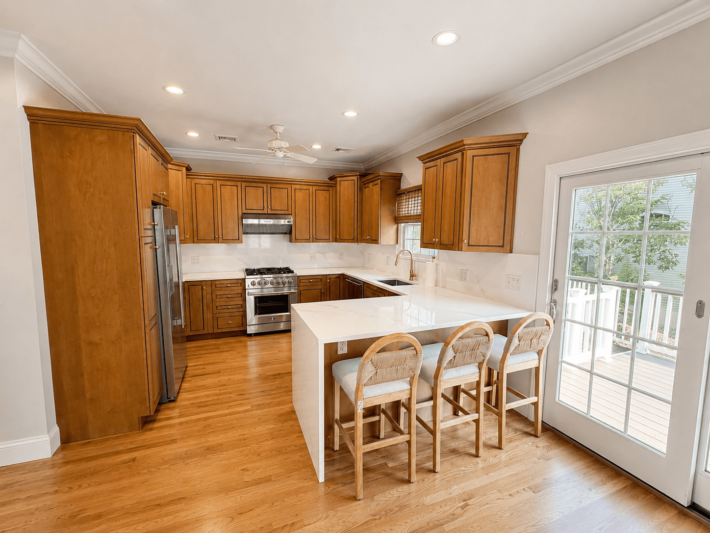 Freshly renovated kitchen with maple cabinets, white quartz countertops, and stainless steel appliances after a post-construction cleaning by Maid With Precision