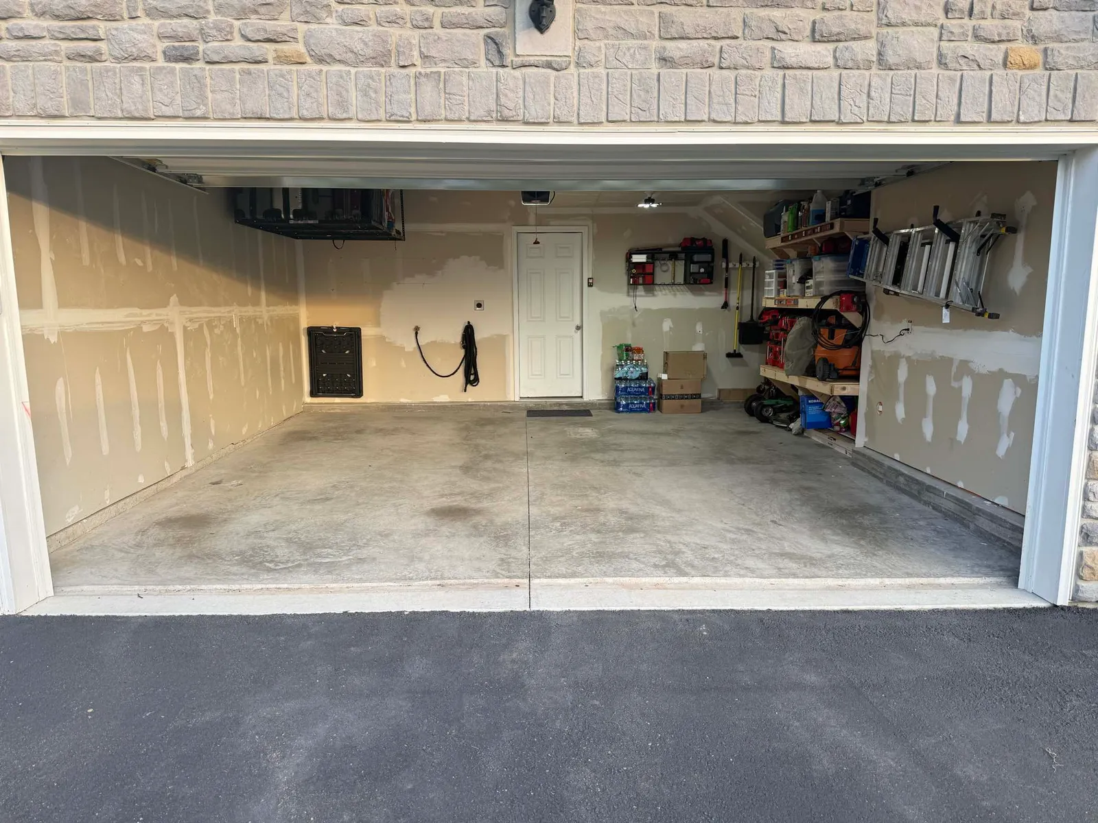 Organized two-car garage with neatly arranged shelving and a clean concrete floor after a Maid With Precision cleanout